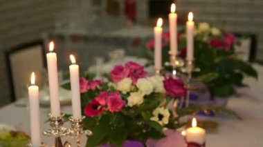 Yanan mumlar ve taze çiçeklerle güzel bir ziyafet masası. Romantik mum ışığında akşam yemeği.