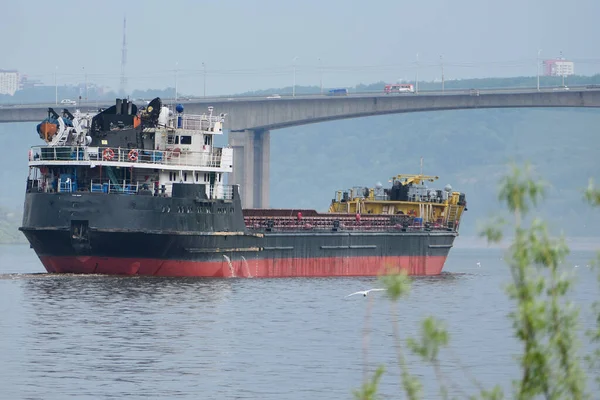 Navio de carga, um grande navio está no rio, a passagem sob a ponte. — Fotografia de Stock