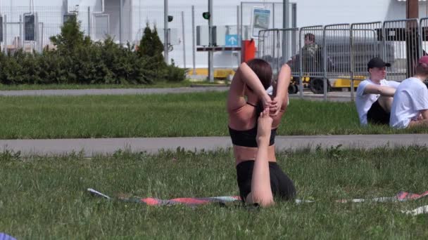 Rusko, Nižný Novgorod, VUO, Volžský nábřeží 43 06.05.2021. Mladá žena dělá jógu na ulici, v — Stock video