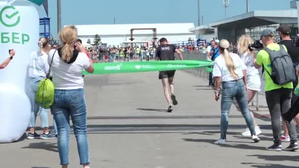 Rússia, N. Novgorod 06.05.2021. Um atleta cruza a linha de chegada em uma maratona — Vídeo de Stock
