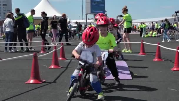 Rússia, Nizhny Novgorod, aterro Volzhskaya 21, 05.06.2021. Crianças, crianças em uma bicicleta de equilíbrio. Parque de diversões das crianças. Crianças brincam — Vídeo de Stock