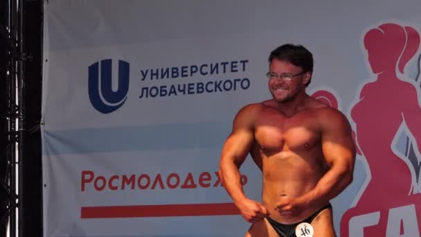 Ryssland, Nizjnij Novgorod, Volga vall 21, 05.06.2021. Kroppsbyggnad. Utförande av en bodybuilder, en idrottsman på scenen. — Stockvideo