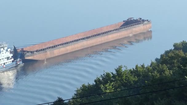 Um rebocador com uma barcaça vai ao longo do rio no verão. Vista do rio navegável. Navegação fluvial. — Vídeo de Stock