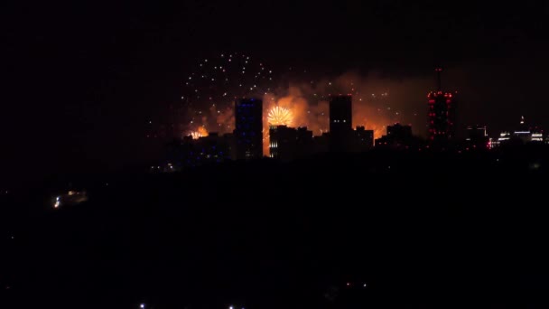 Fuegos artificiales festivos en el cielo nocturno sobre la ciudad. — Vídeos de Stock