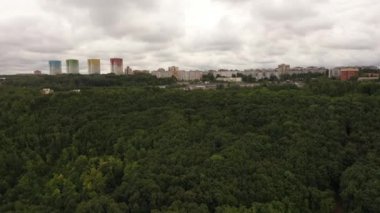 Ormanın panoramik manzarası, parkın yanı, şehrin içi. Havadan ateş ediyorlar. Hava fotoğrafçılığı. Yüksek kaliteli FullHD görüntüler
