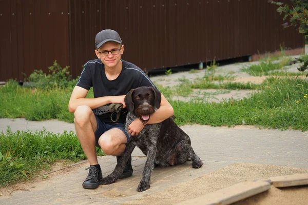 A man with a dog. A young man with his hunting dog on the street. — Stock Photo, Image