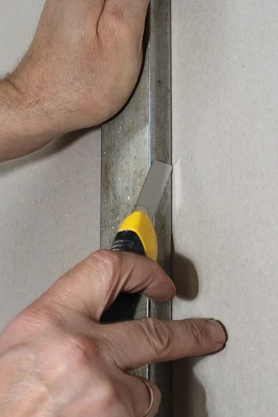 Cutting gypsum board with a knife on the rail. — Stock Photo, Image