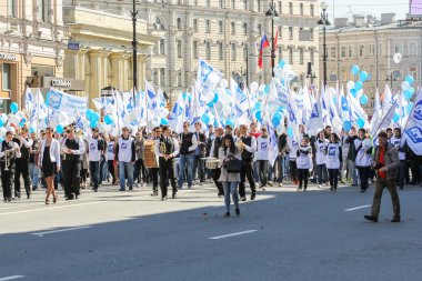 Mavi ve beyaz bayrakları altında kişi.