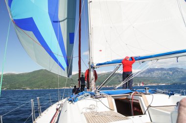 Yelkenlerin altındaki güvertedeki insanlar..