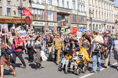Bebek arabasında çocuklu insanlar.