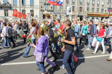 İnsanlar çiçek ve bayrakları ile.