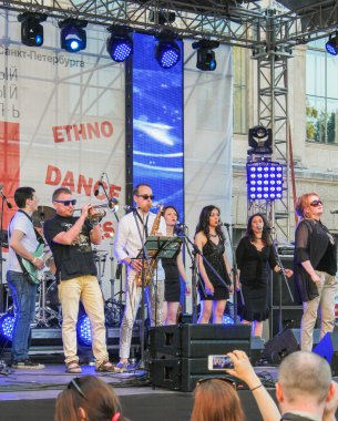 Mavi bir arka plan ile sahnede sanatçı.