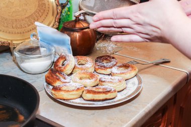 Pudra şekeri ile çörek serpme.
