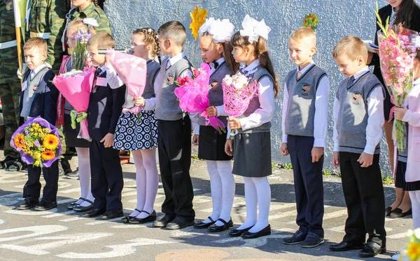 La línea de escolares con ramos de flores . — Foto de Stock