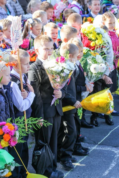 La línea de escolares con flores . — Foto de Stock