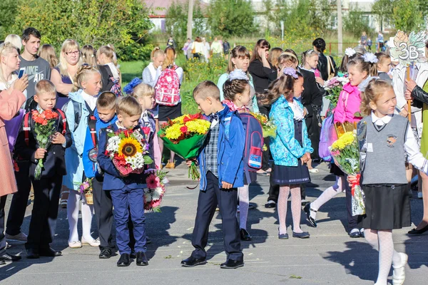 Kinderen met bloemen naar de school te gaan. — Stockfoto