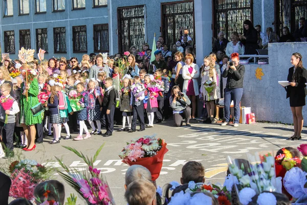 Dospělí a děti s květinami. — Stock fotografie