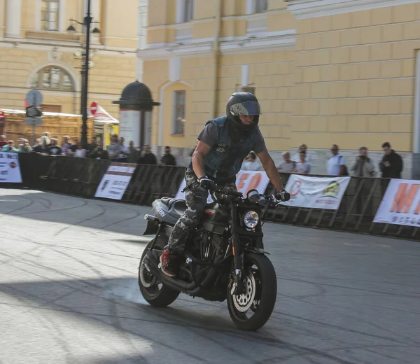 Jezdecký biker stojící pod koly s kouřem. — Stock fotografie