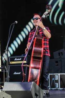 Müzisyen sahnede güneş gözlüğü takıyor.