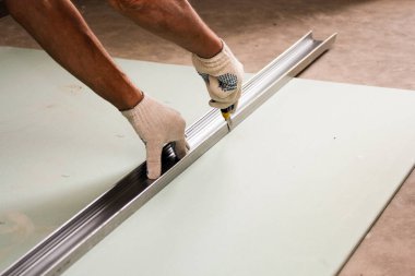 Duvara çekiçle vuruyor. Konut binalarının yeni apartmanlarında inşaat ve bitirme işleri.