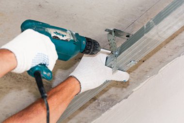 Duvara çekiçle vuruyor. Konut binalarının yeni apartmanlarında inşaat ve bitirme işleri.