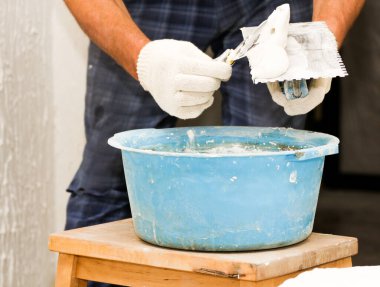 Duvara çekiçle vuruyor. Konut binalarının yeni apartmanlarında inşaat ve bitirme işleri.