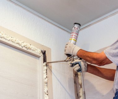 Boşluğu tabancanın poliüretan köpüğüyle dolduruyor..