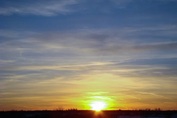 Untergehende Sonne über dem dunklen Feld — Stockfoto