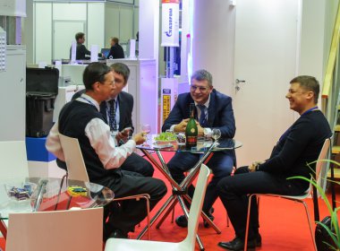 Brendi ile masada dört iş adamları.