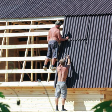 Yan çatı eğimi kapsayan işçi.