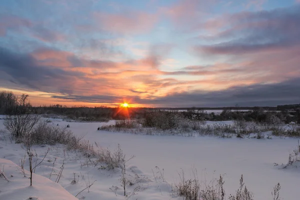 Zachód słońca nad polu zima. — Zdjęcie stockowe