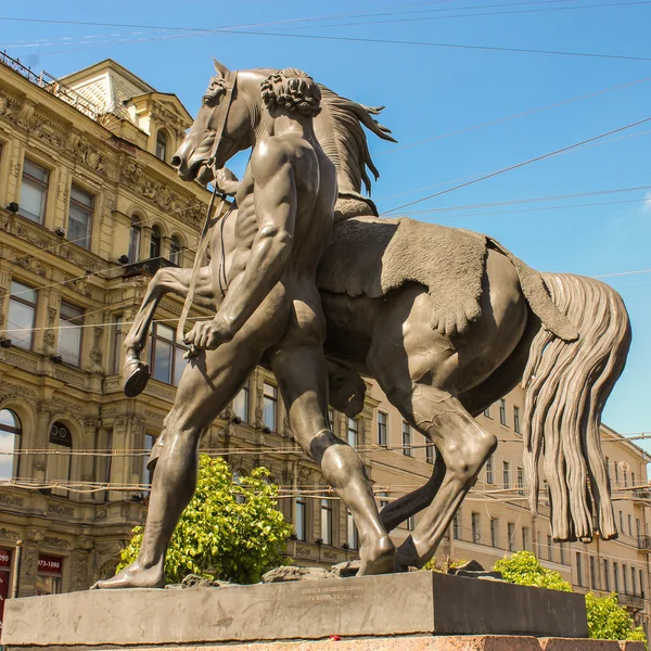 Bir adamın yanında bir at heykeli