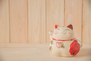 ahşap masa arka plan üzerinde Çince şanslı kedi