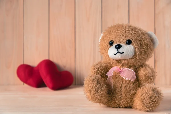 Teddybär mit Paar rotem Herz Hintergrund auf Holztisch — Stockfoto