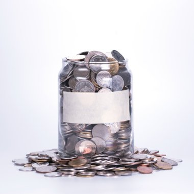 Beyaz arkaplanda cam kavanozdaki madeni paralar