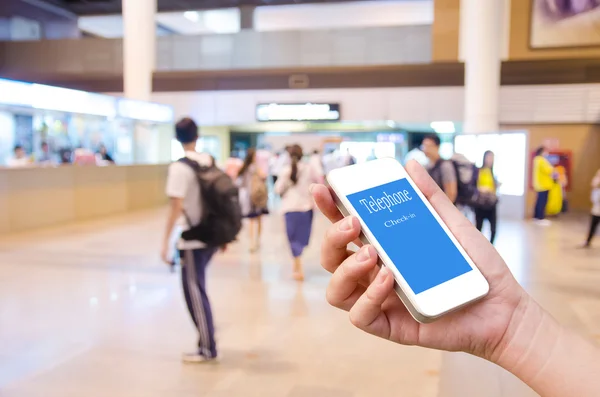 Mão segurando telefone celular para check-in móvel com borrado mesmo — Fotografia de Stock