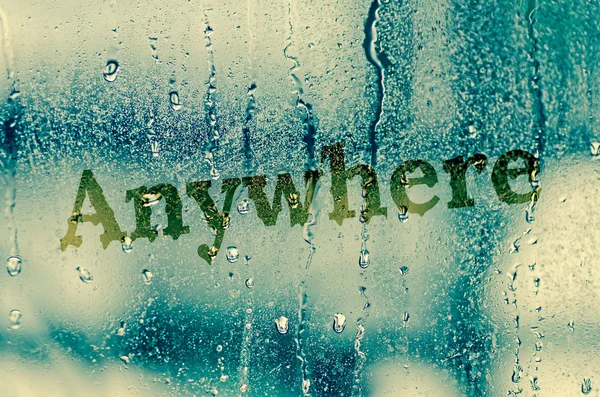 Natural water drops on glass window with word "Anywhere" — Stock Photo, Image