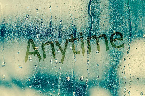 Natural water drops on glass window with word "Anytime" — Stock Photo, Image