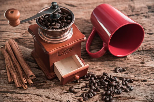 Ahşap masa üzerinde kırmızı Kupası ile kahve öğütücü