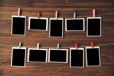 clothespins ile ahşap arka plan asılı boş fotoğraf çerçeveleri