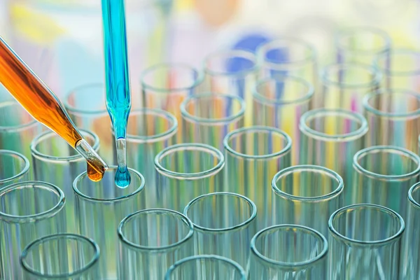 Science pipette with a drop of substance over laboratory test tube — Stock Photo, Image