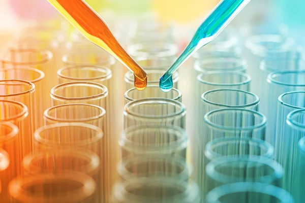 Science pipette with a drop of substance over laboratory test tube — Stock Photo, Image