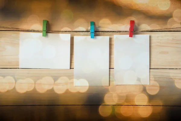 Leere Fotorahmen, die mit Wäscheklammern auf Holzgrund hängen — Stockfoto