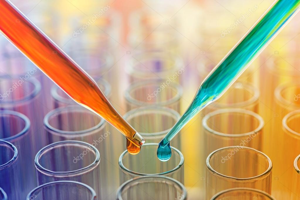 Science pipette with a drop of substance over laboratory test tube