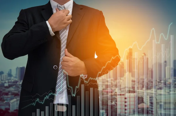 Business man with graph on virtual screen and city background — Stock Photo, Image