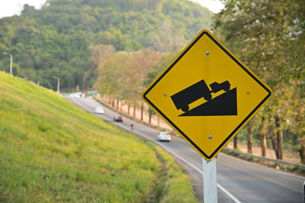 Road sign slope up on beautiful long road background — Stock Photo, Image