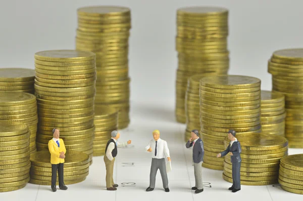 Miniature people team agreement with stack of coins and calendar — Stock Photo, Image