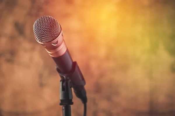Black microphone with blurred old world map background — Stock Photo, Image