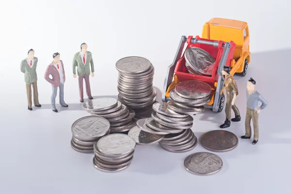 Miniatyr team försöker bygga mynt stack — Stockfoto