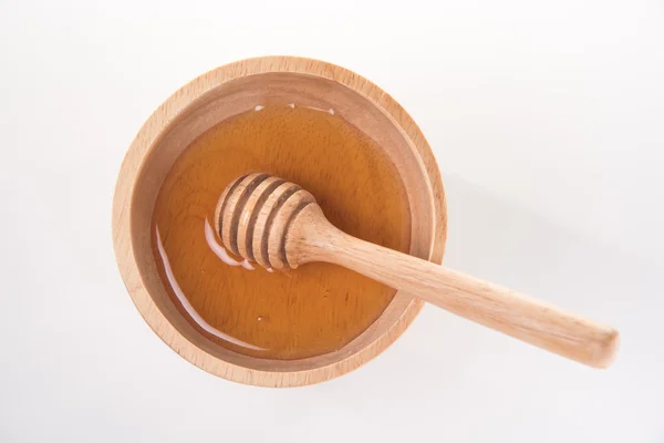 Wooden honey dipper in honey bowl — Stock Photo, Image